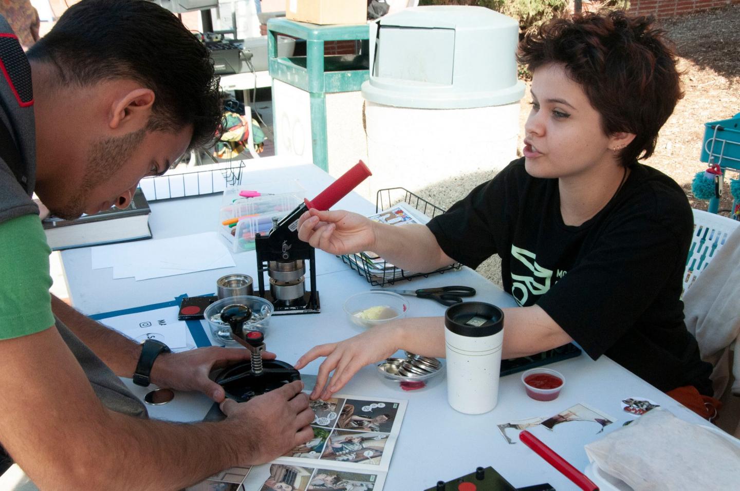 Moorpark College Club Rush, two students make buttons with comic book graphics