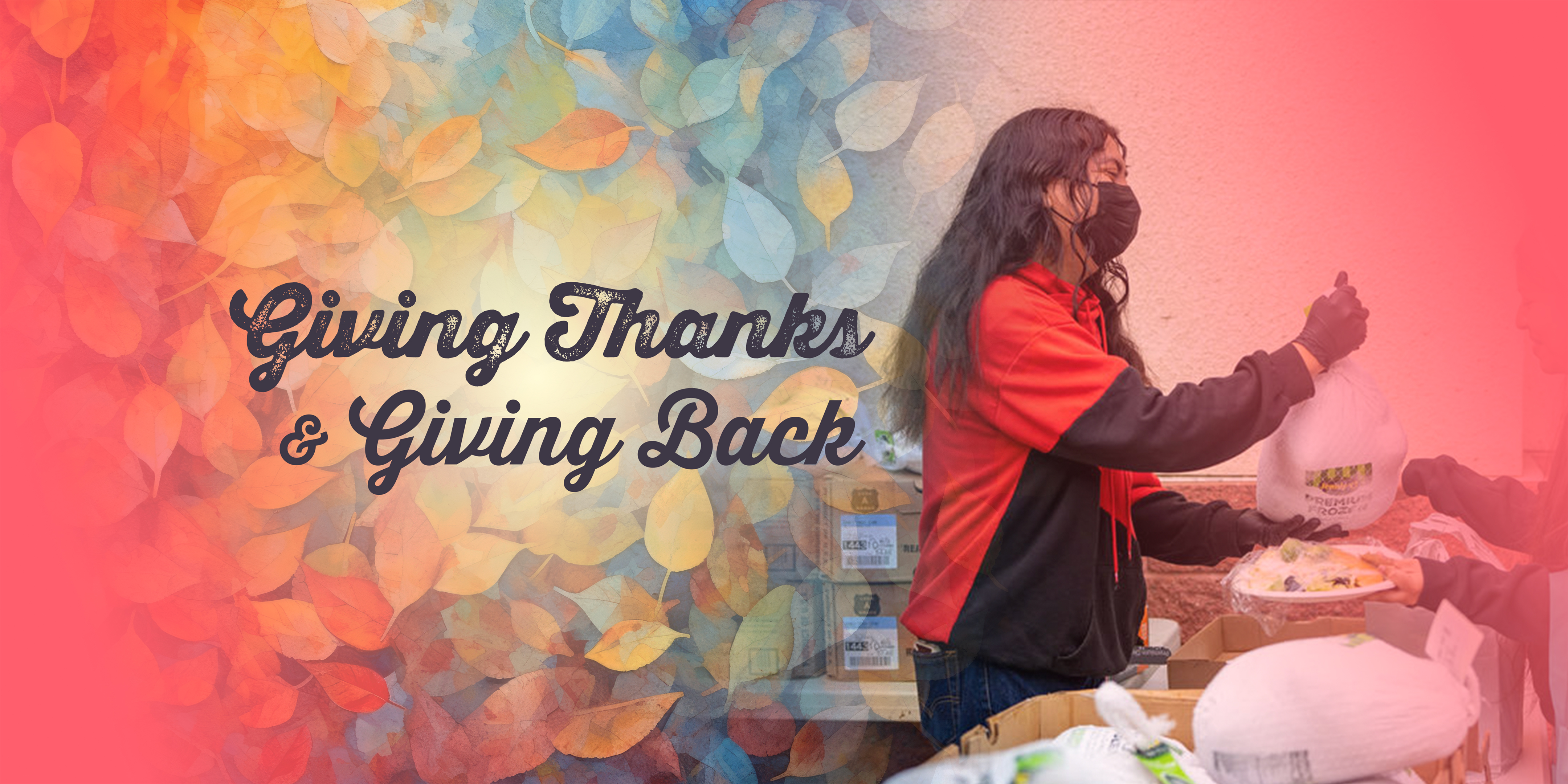 Person wearing a mask distributes food during a community drive, with the words “Giving Thanks & Giving Back” over a background of autumn leaves.