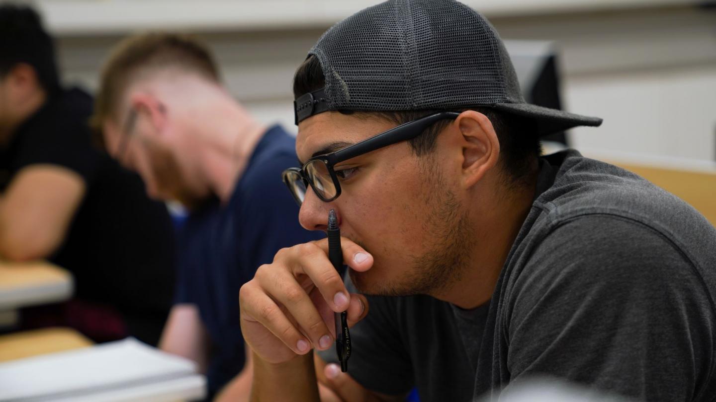 Male student concentrating on what he's reading