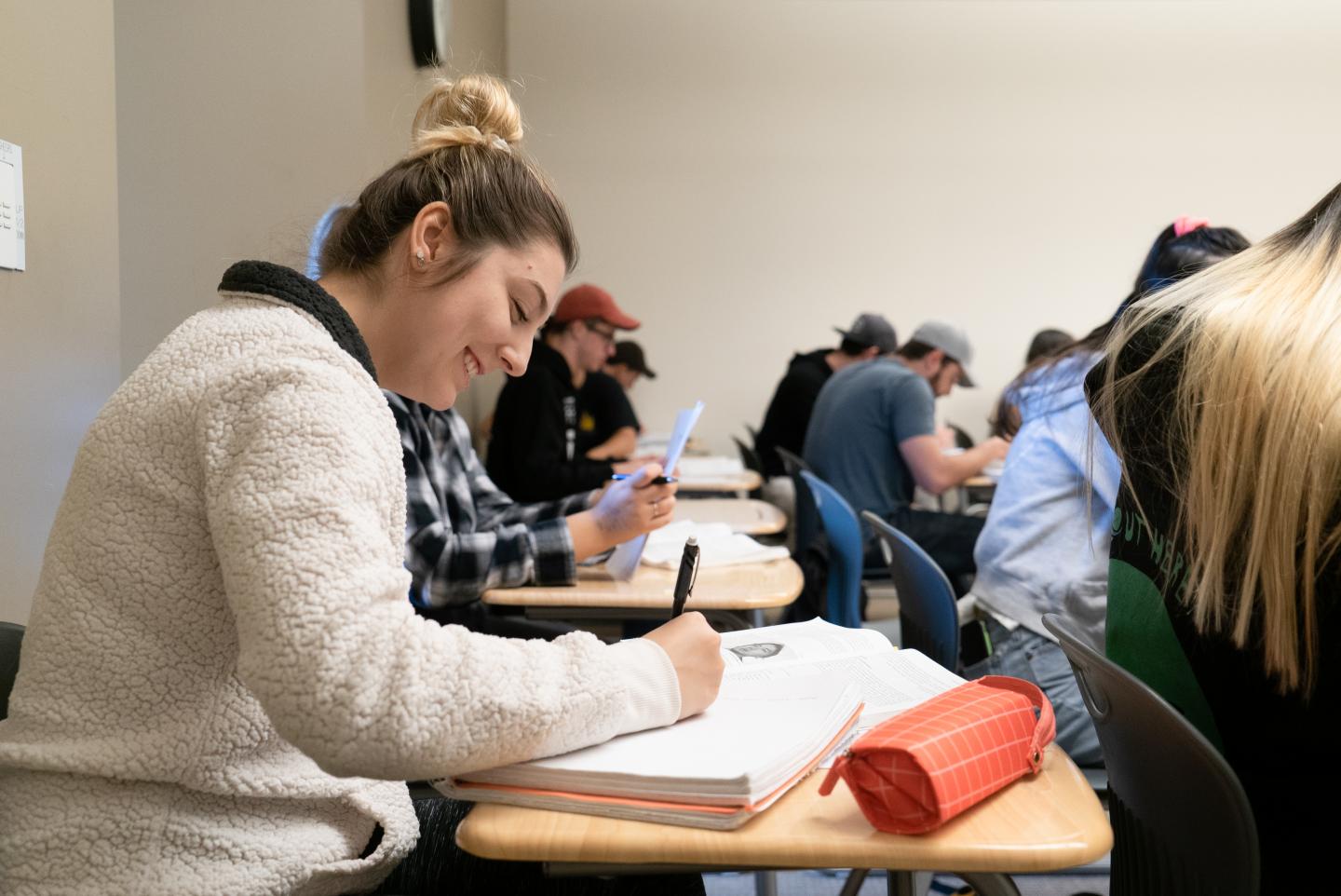 female student at moorpark college taking notes in a notebook during a class