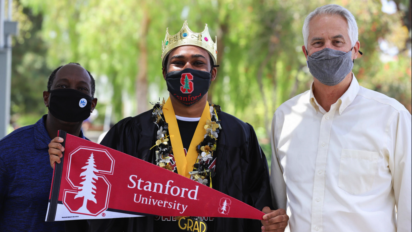 Gerald Richardson III holding a Stanford University flag with Moorpark President Sokenu and Chancellor Gillespie all wearing masks.