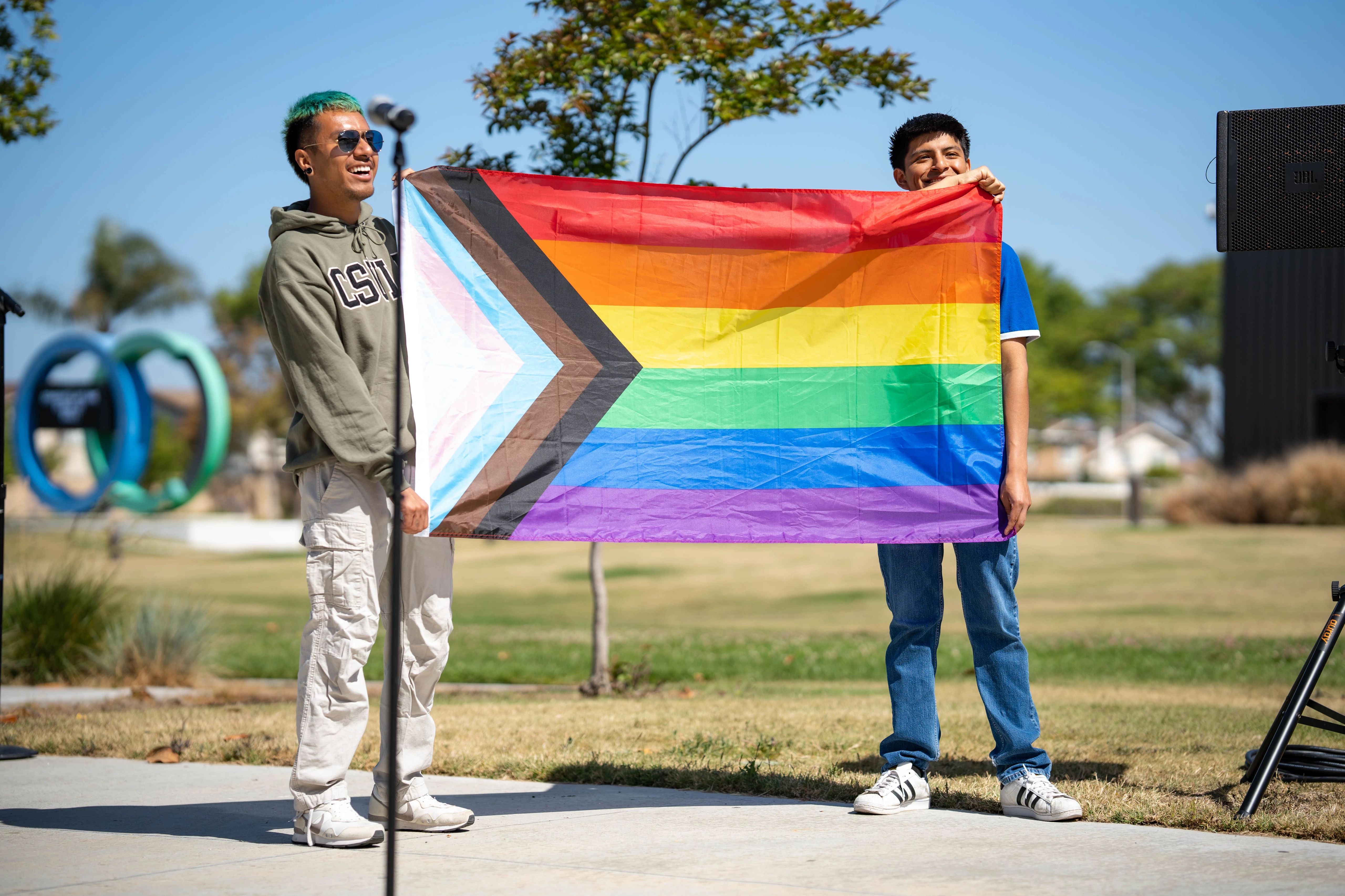 Students hold up the Progress Pride flag
