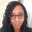 picture of a black haired woman with braids smiling at the camera