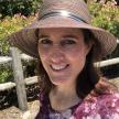 Renee Butler, brown hair, wearing a sun hat and purple blouse with white flowers