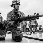 Jack Twitchell in full firefighter garb with a fire hose. 