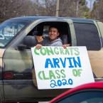 Drive thru graduation at Oxnard College, student holding a sign saying "Congrats Arvin Class of 2020"