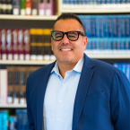 Image of Dr. Oscar Cobian posing in front of bookcase