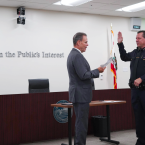 Chancellor MacLennan swearing in new Chief of Police Robert Davidson Monday, September 22, 2025. Text on the wall says “Service in the Public’s Interest.”