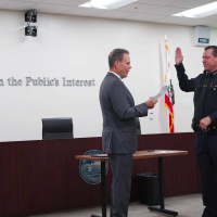 Chancellor MacLennan swearing in new Chief of Police Robert Davidson Monday, September 22, 2025. Text on the wall says “Service in the Public’s Interest.”