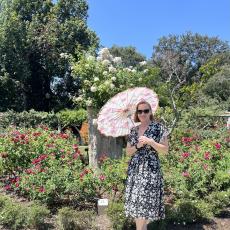 Rachel Johnson in a garden with a parasol