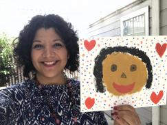 A picture of me smiling holding a painting of a a picture of me my daughter painted.