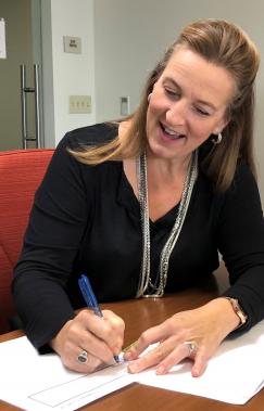 Deanna Hall signing paperwork