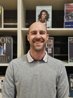 Photo of Robbie in front of a library display at Oxnard College