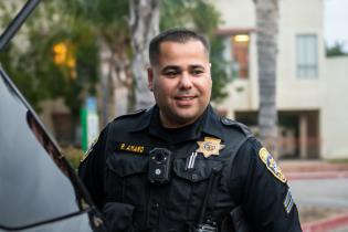 Photo of Officer Amaro behind police vehicle at Oxnard College