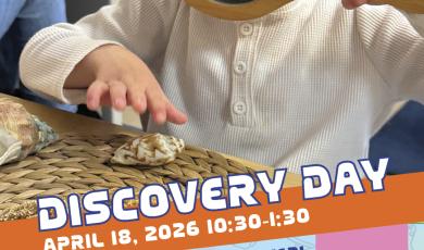 Discovery Day toddler with magnifying glass looking at shell