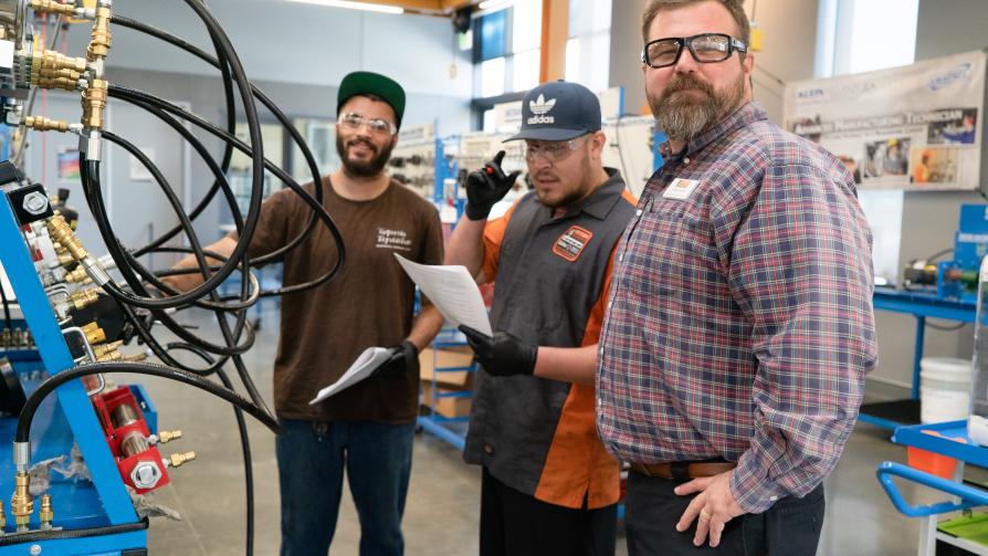 Photo of Manufacturing Technology Professor John Clark, with two students working in the Advanced Manufacturing Lab