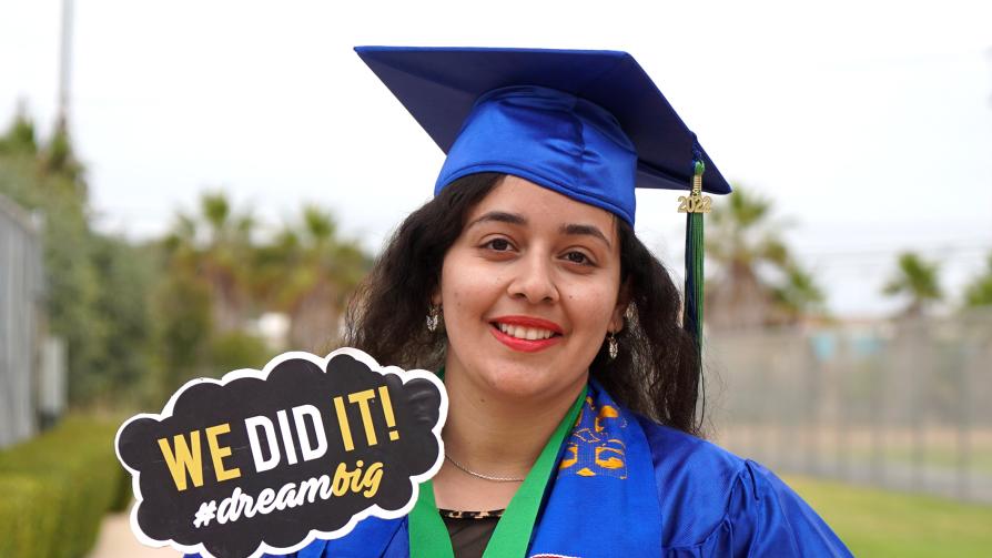 Oxnard College graduate holding a sign that says We did it! #dreambig