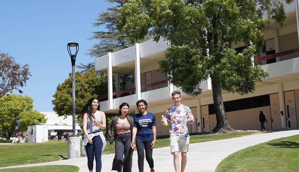 Four Moorpark College students walking around campus.