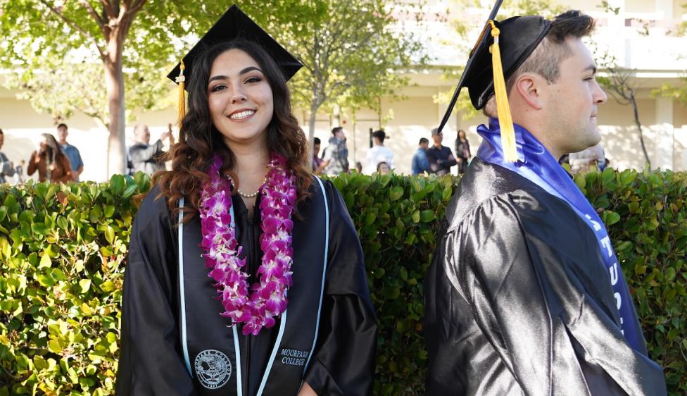 Two Moorpark College graduates standing in line to receive their degree or certificate.