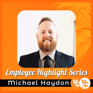 Michael Haydon, wearing a suit and tie; orange background wi