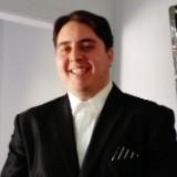 Image: MC Alum Waheed Akberzie smiling, wearing a black suit Image: MC Alum Waheed Akberzie smiling, wearing a black suit