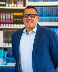 Image of Dr. Oscar Cobian posing in front of bookcase