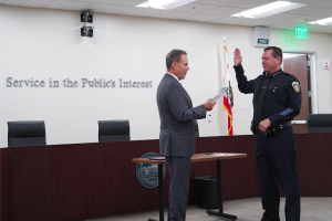 Chancellor MacLennan swearing in new Chief of Police Robert Davidson Monday, September 22, 2025. Text on the wall says “Service in the Public’s Interest.”