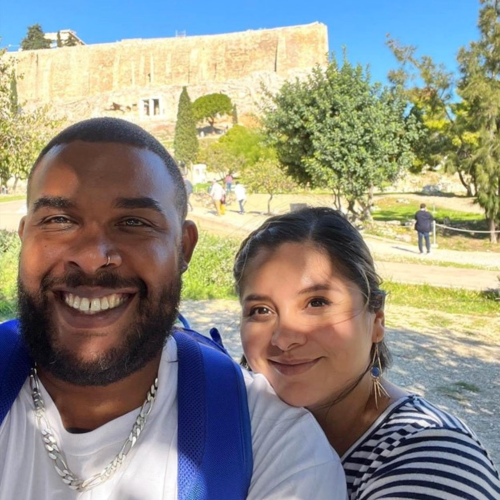 Tisa and her husband outside on a trip to Greece